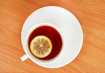 top plan of a tea cup with lemon on wooden table