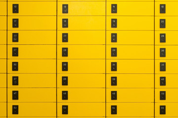 Gelbe Postfächer mit Nummerierung auf schwarzen Schildern