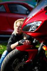 Fototapeta na wymiar The blonde sitting about a red motorcycle