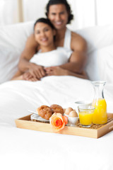 Obraz na płótnie Canvas Couple having breakfast on the bed