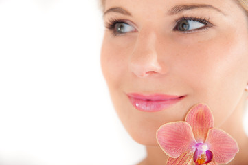 Young healthy woman with pure skin and flower