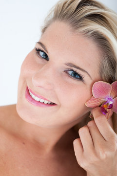 Young healthy woman with pure skin and flower