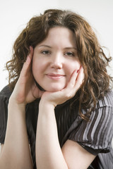 portrait of young smiling woman props her face in