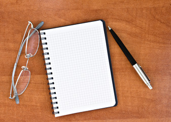 glasses, notepad with pen