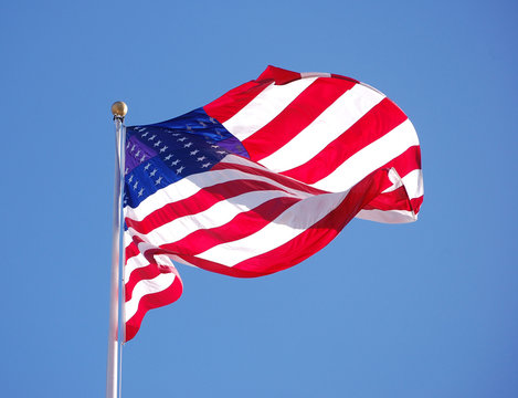 American flag waiving in the wind with blue sky