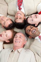 Fototapeta na wymiar Laughing Business team lying in a circle