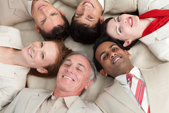 Business team lying on the floor with heads together