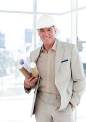 Senior architect with a hardhat holding blueprints