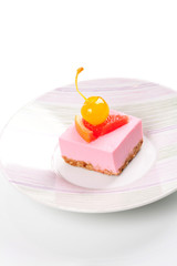 Pink cheesecake with maraschino cherry and grapefruit slice