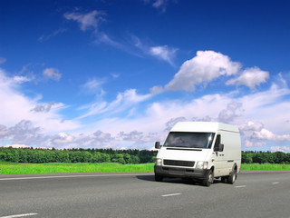 Fototapeta na wymiar biały van na drogach kraju pod błękitne niebo