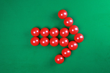 Red snooker balls with arrow shape on green background