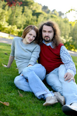 Fototapeta na wymiar Young couple sitting on the grass in a park
