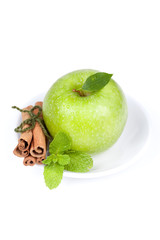 A Ripe Green Apple with mint and cinnamon on plate