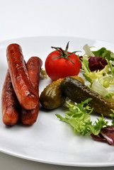 smoked sausage and organic gherkin on a plate