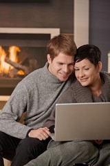 Couple using laptop at winter