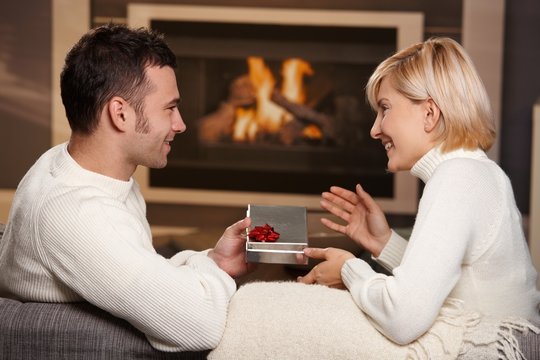 Couple exchanging gift at home