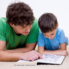 Naklejka premium Father and son indoors reading book