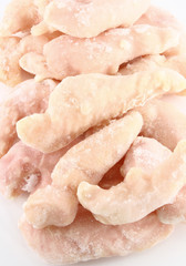 Pile of frozen chicken thighs close up