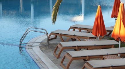 Swimming-Pool mit Liegen und Sonnenschirmen