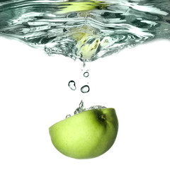 Fototapeta na wymiar green apple dropped into water with splash isolated on white