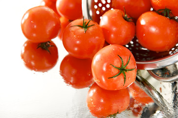 dojrzale czerwone pomidory w sitku, na białym tle, mokre, lustro - obrazy, fototapety, plakaty