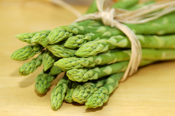 green organic asparagus and a timber background