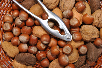 some organic nuts in a basked and a nutcracker