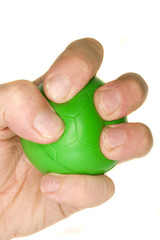 a man's hand squeezing a green stress ball.