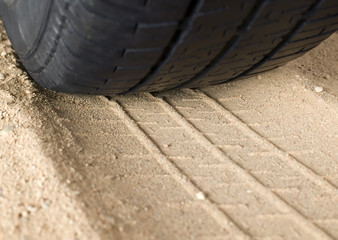 Obraz premium Black tyre and track on sand