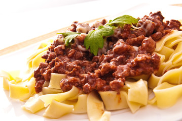 spaghetti bolognese with cheese on white plate