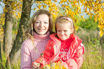 mother with little girl against autumn park