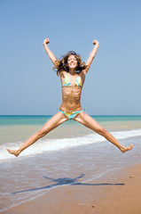 Attractive girl jumping on the beach