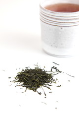 green tea - both hot beverage/infusion and dry leafs on white ba