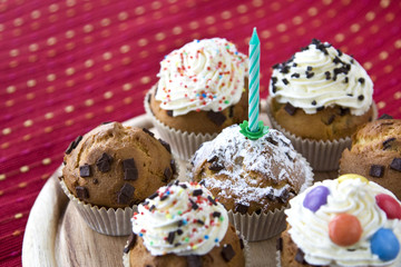 Muffins mit Schlagsahne und einer Kerze