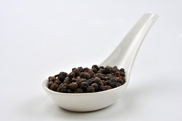 black organic pepper and a white background