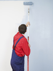 mann renoviert wohnung streicht wand hellblau