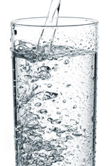 Water pouring into glass on white background