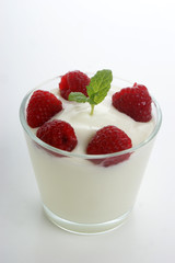 some organic raspberries in natural yogurt and mint