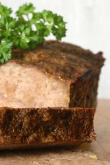 baked meat loaf with organic parsley on a timber board
