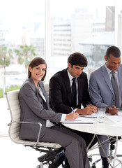 Young businesswoman sitting at a conference table with her team