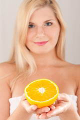 Young healthy smiling woman with citrus orange fruit