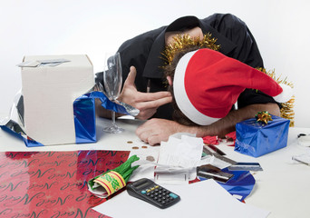 Man in Santa Claus hat loooking depressed about his finances.