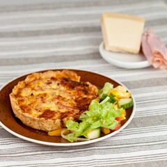 Pie dinner with cheese and ham and some salad