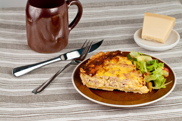 Pie dinner with cheese and ham and some salad
