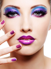 Beautiful female face with purple glamour make-up