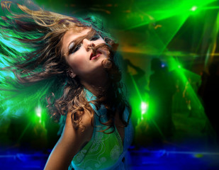 Beautiful young woman dancing in the nightclub.