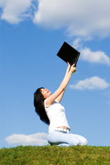 pretty woman with laptop on the green grass