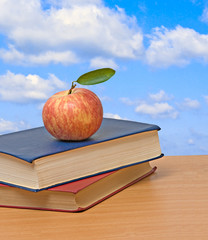Red apple and books on desk