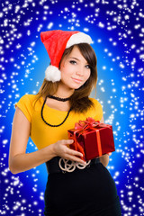Beautiful smiling woman in a santa hat with gift in box