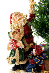 Statue of Santa Claus with children bij bare christmas tree